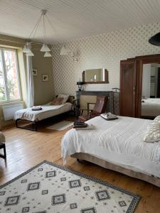 a bedroom with two beds and a mirror at Domaine du plô, Tarn in Trévien