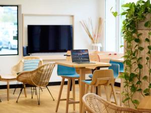 ein Tisch mit Stühlen und einem Laptop darauf in der Unterkunft ibis Styles Bordeaux Begles Arena in Bègles