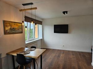 een woonkamer met een houten tafel en een tv bij New apartament in city center in Sigulda