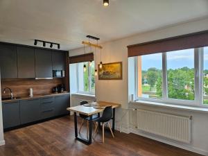 een keuken met een tafel en stoelen en een raam bij New apartament in city center in Sigulda
