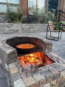 a fire pit with a pan of food in it at Cabañas Punto Prana in Tandil