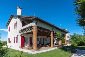 ein rot-weißes Haus mit Veranda in der Unterkunft Maranghetto appartamenti in Caorle