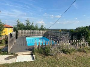 a wooden fence with a swimming pool in a yard at Cascina Teresina Monferrato Piscina in Cortazzone