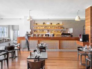 een restaurant met tafels en stoelen en een bar bij Mantra Lorne in Lorne