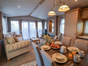 a living room with a table and a couch at Paws By The Sea in Norwich