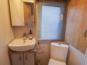 a small bathroom with a sink and a toilet at Paws By The Sea in Norwich +13 photos