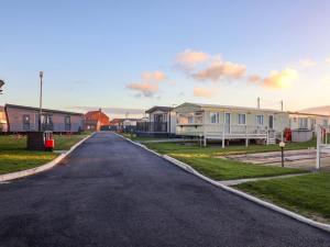 an empty street with houses on the side of a road at Paws By The Sea in Norwich