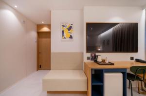 a room with a desk and a tv on the wall at Daisy hotel in Tongyeong