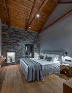 een slaapkamer met een groot bed en een bakstenen muur bij EJ Boutique Suites in Milína