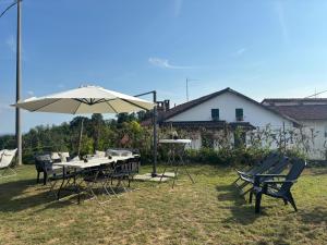 a table and chairs with an umbrella in a yard at Cascina Teresina Monferrato Piscina in Cortazzone