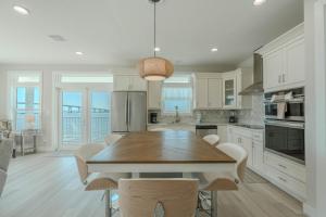 a kitchen with a wooden table and a dining room at Punta Rassa Pointe by Sun Palace Vacations in Fort Myers