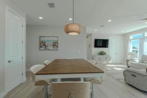 a dining room and living room with a table and chairs at Punta Rassa Pointe by Sun Palace Vacations in Fort Myers