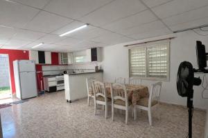 a kitchen with a table and chairs and a refrigerator at Casa El Trapiche Lo Altos in Trapiche