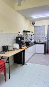 een keuken met een houten tafel in een keuken bij Homestay Tanjung Malim DMalim in TanjongMalim +3 foto's