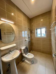 a bathroom with a toilet and a sink and a mirror at Hôtels Résidences Easy in Cotonou