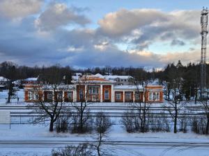 een huis in een met sneeuw bedekt veld met bomen bij New apartament in city center in Sigulda