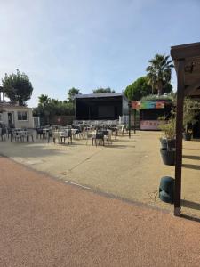 a parking lot with tables and chairs and a screen at Mobil-Home L'Escale-MH34 Les Sables du Midi in Sérignan