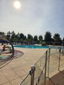 a large swimming pool with people in the water at Mobil-Home L'Escale-MH34 Les Sables du Midi in Sérignan