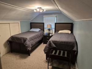 a bedroom with two beds and a chair in it at Bourbon Belle of Bardstown in Bardstown