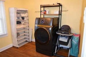 a laundry room with a washing machine and a shelf at Bourbon Belle of Bardstown in Bardstown