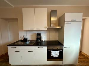 a kitchen with white cabinets and a sink at Stilvolles 2-Zimmer-Apartment in Bremen in Bremen