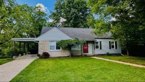 a white house with a red door in a yard at Bourbon Belle of Bardstown in Bardstown