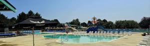 a swimming pool with chairs and a water park at O'ContisParadise 2 in Saint-Julien-en-Born