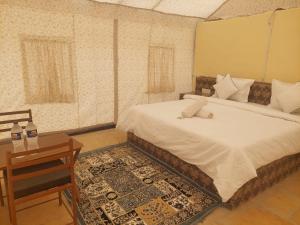 a bedroom with a bed and a desk and a bed sidx sidx sidx at Raj Kesari Heritage Camp in Jaisalmer