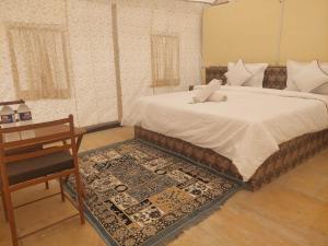 a bedroom with a bed and a table and a desk at Raj Kesari Heritage Camp in Jaisalmer