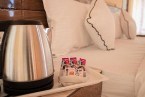 a coffee pot on a tray next to a bed at Raj Kesari Heritage Camp in Jaisalmer +2 photos