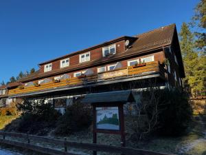 a large wooden building with a sign in front of it at Wald-Landhaus in Hahnenklee-Bockswiese