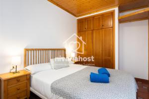 una camera da letto con un letto e una sedia blu sopra di El Pescador El Pris, by Nivariahost a El Pris