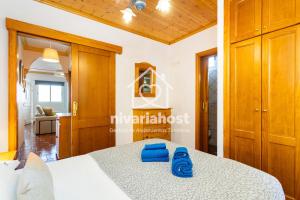 una camera da letto in una casa con un letto e pantofole blu di El Pescador El Pris, by Nivariahost a El Pris Altre 21 foto