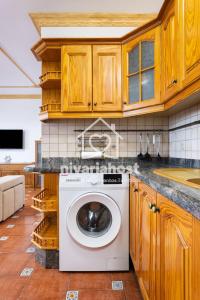 una lavatrice in una cucina con armadi in legno di El Pescador El Pris, by Nivariahost a El Pris