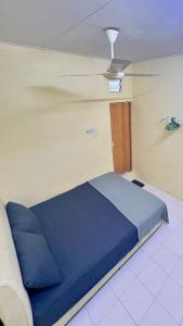 een slaapkamer met een blauw bed in een kamer bij Homestay Tanjung Malim DMalim in TanjongMalim