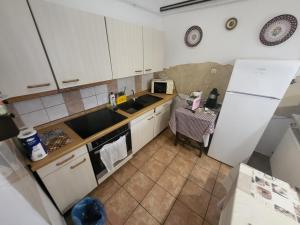 a kitchen with a white refrigerator and a table at THERMÁL vendégház in Sárospatak +18 photos