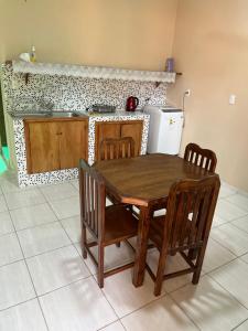 a kitchen with a wooden table and chairs and a stove at Departamentos a Pasos de la Basílica in Caacupé