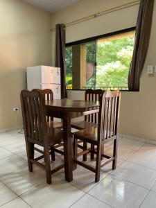 a dining room table with two chairs and a refrigerator at Departamentos a Pasos de la Basílica in Caacupé