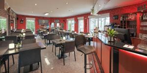 een restaurant met een bar, tafels en stoelen bij DUA Hotel in Sarstedt