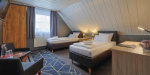een hotelkamer met twee bedden en een bureau bij DUA Hotel in Sarstedt +74 foto's