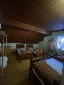 una camera con tre letti e un soffitto in legno di Rifugio La Capanna a Claviere