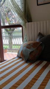 a bed with a pillow on it with a window at LaelleApartament Rho Fiera San Siro in Cornaredo