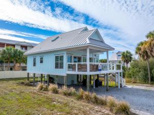 una casa blu con tetto in metallo di Gone Coastal by Pristine Properties Vacation Rentals a Mexico Beach