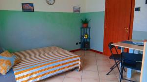a bedroom with a bed and a table and a desk at LaelleApartament Rho Fiera San Siro in Cornaredo
