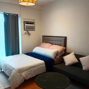 Giường trong phòng chung tại Cozy Staycation Amani Grand Resort Residences Near Cebu Airport with Pool & Gym , Free Wifi