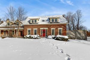 a house with a red door in the snow at Stowe Mountain Road Retreat in Stowe
