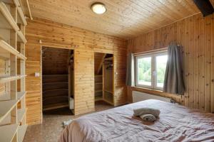 a bedroom with a bed in a wooden cabin at Le Chalet Rustique in Spa