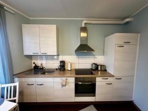 a kitchen with white cabinets and a stove top oven at Zentrales Hansa Komfort Apartment in Bremen