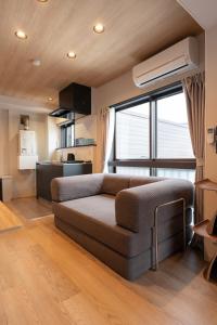 un soggiorno con un divano e una grande finestra di AURA YUZAWA Apartment Hotel - 1Bedroom Apartment with Living Dining Kitchen Sleeps 2 to 4, Bedroom with 2-Double Bed, Living Room with 1-Sofa Bed a Yuzawa