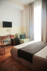 a bedroom with a bed and a desk and a chair at Albergo Garisenda con terrazza panoramica sulle Due Torri in Bologna